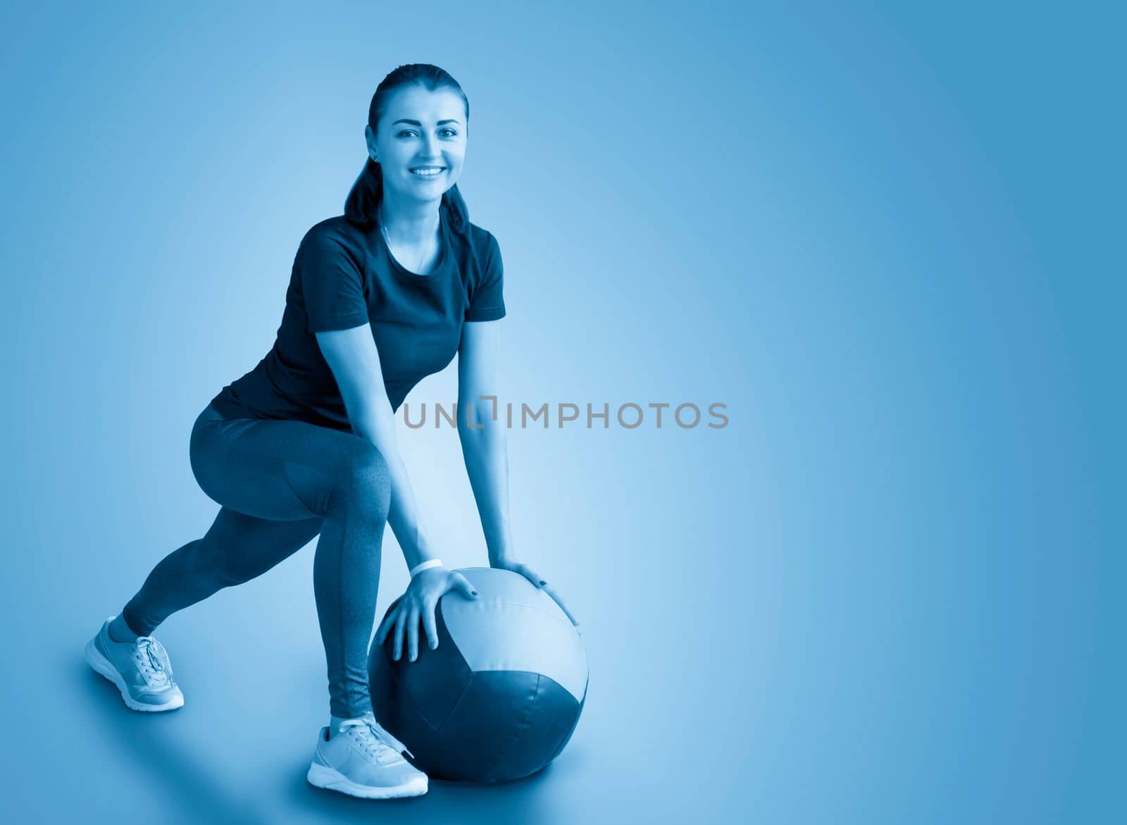 woman in gym relaxing with medicine ball by Mariakray