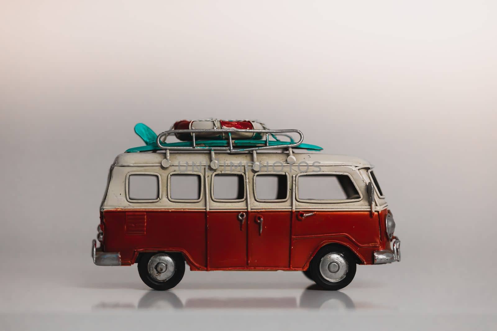 Red and white retro car toy model isolated on white. Toy retro Minivan with surf. Tervuren - November 30 2022