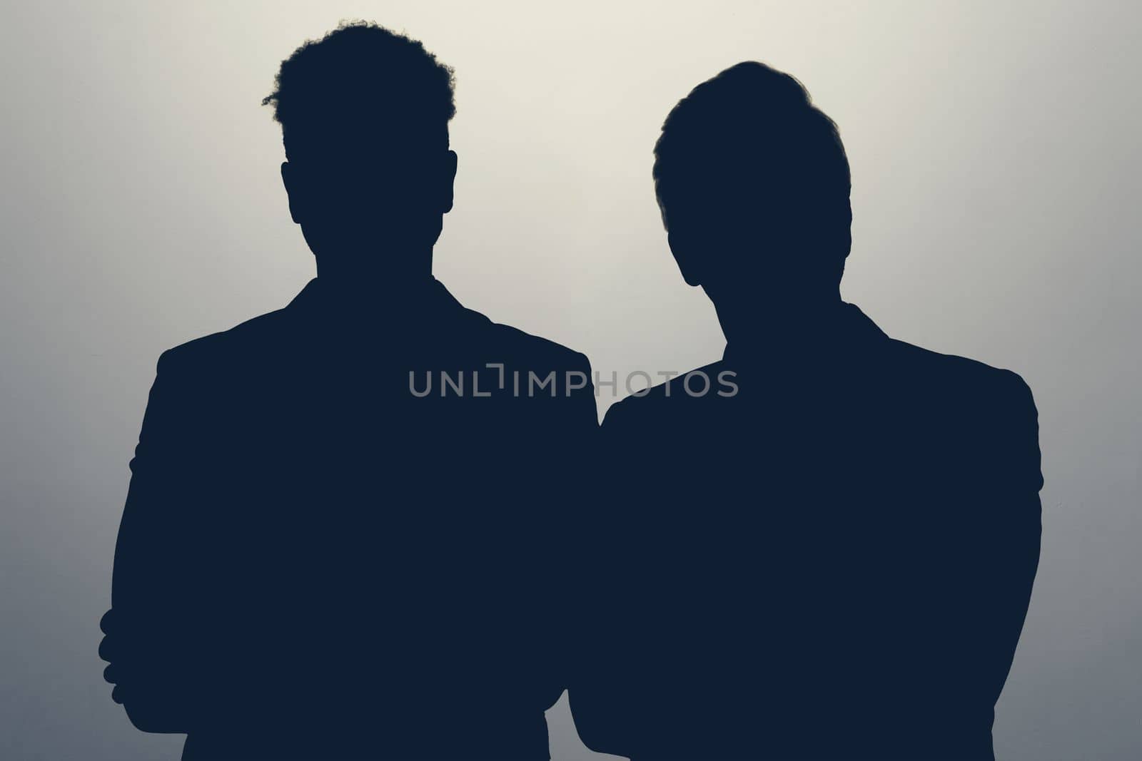 Two male silhouettes in studio. Two men standing together staying anonym hiding their identity. High quality photo