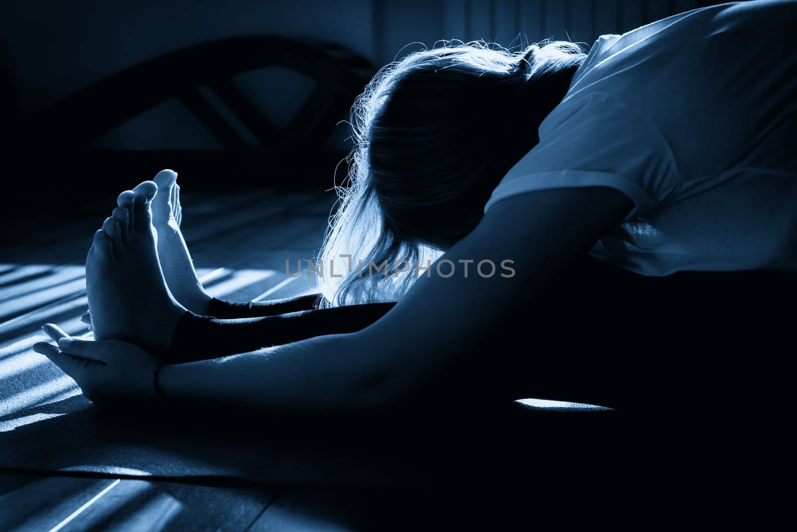 Beautiful young woman stretching in yoga pose on mat by Mariakray