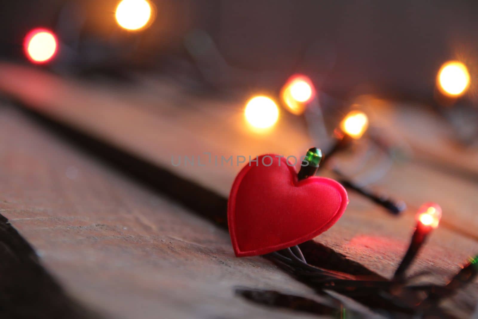 Red heart and Christmas lights on vintage background. New Year home decorations. by Markgraf