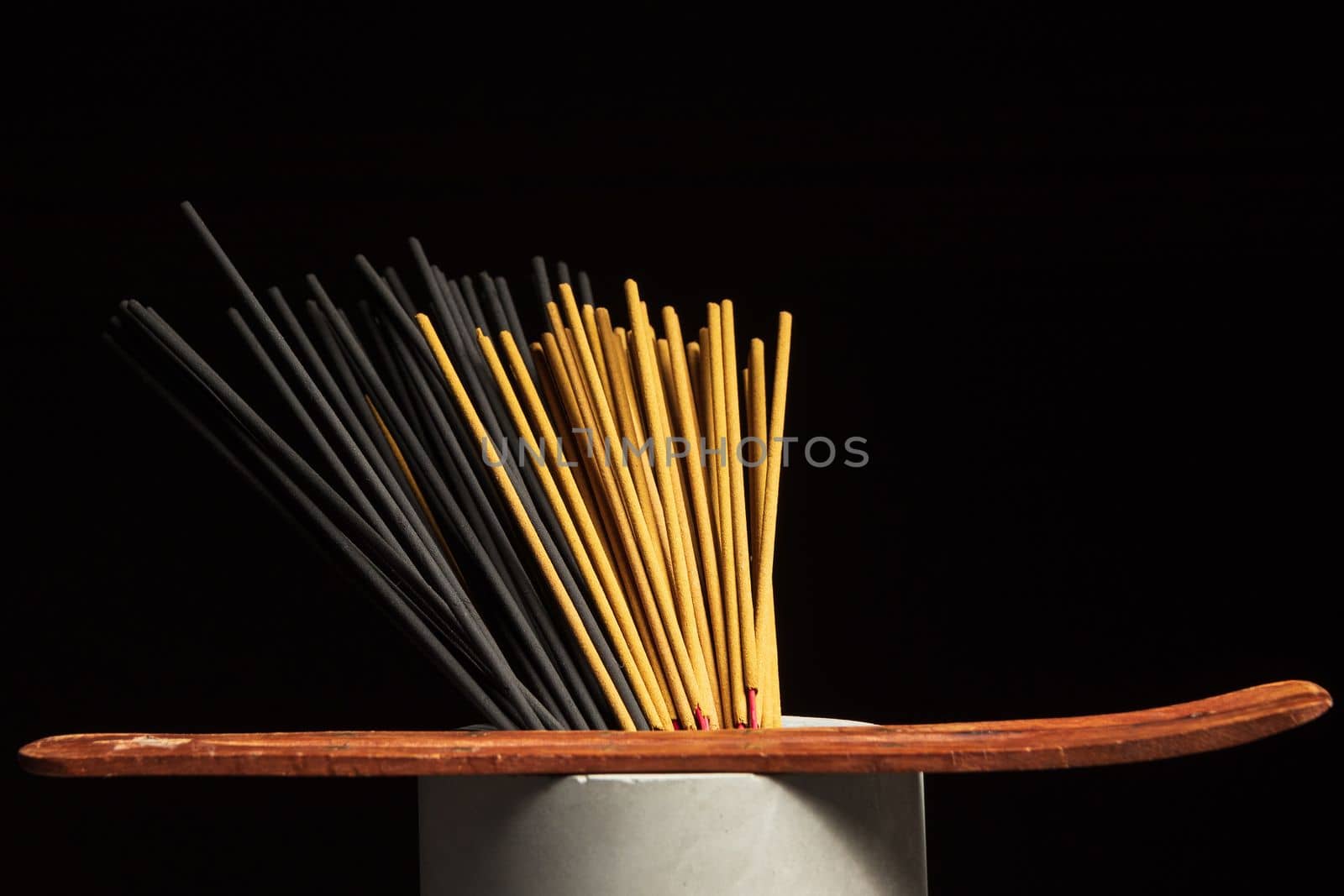 Many different incense sticks with wooden stand.