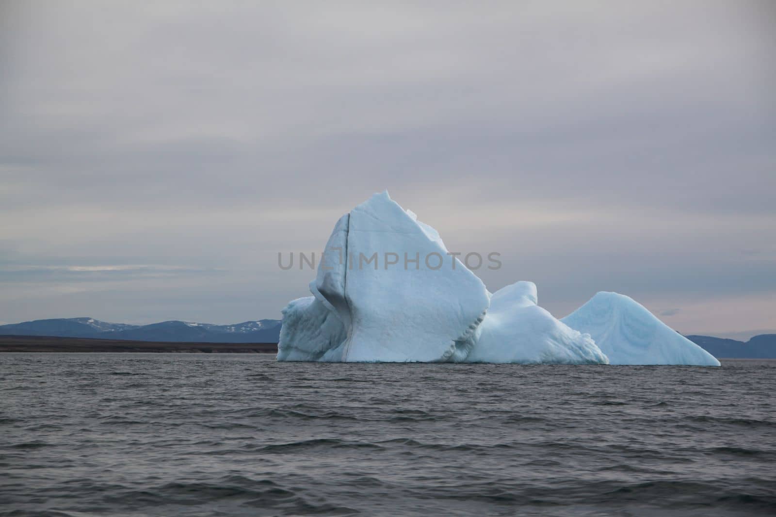 Stranded iceberg and ice near evening in arctic landscape, near Pond Inlet, Nunavut by Granchinho