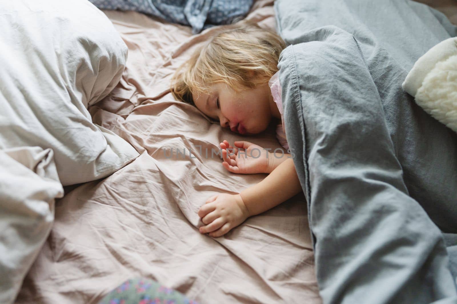 Toddler girl sleeping in her bed by Varaksina