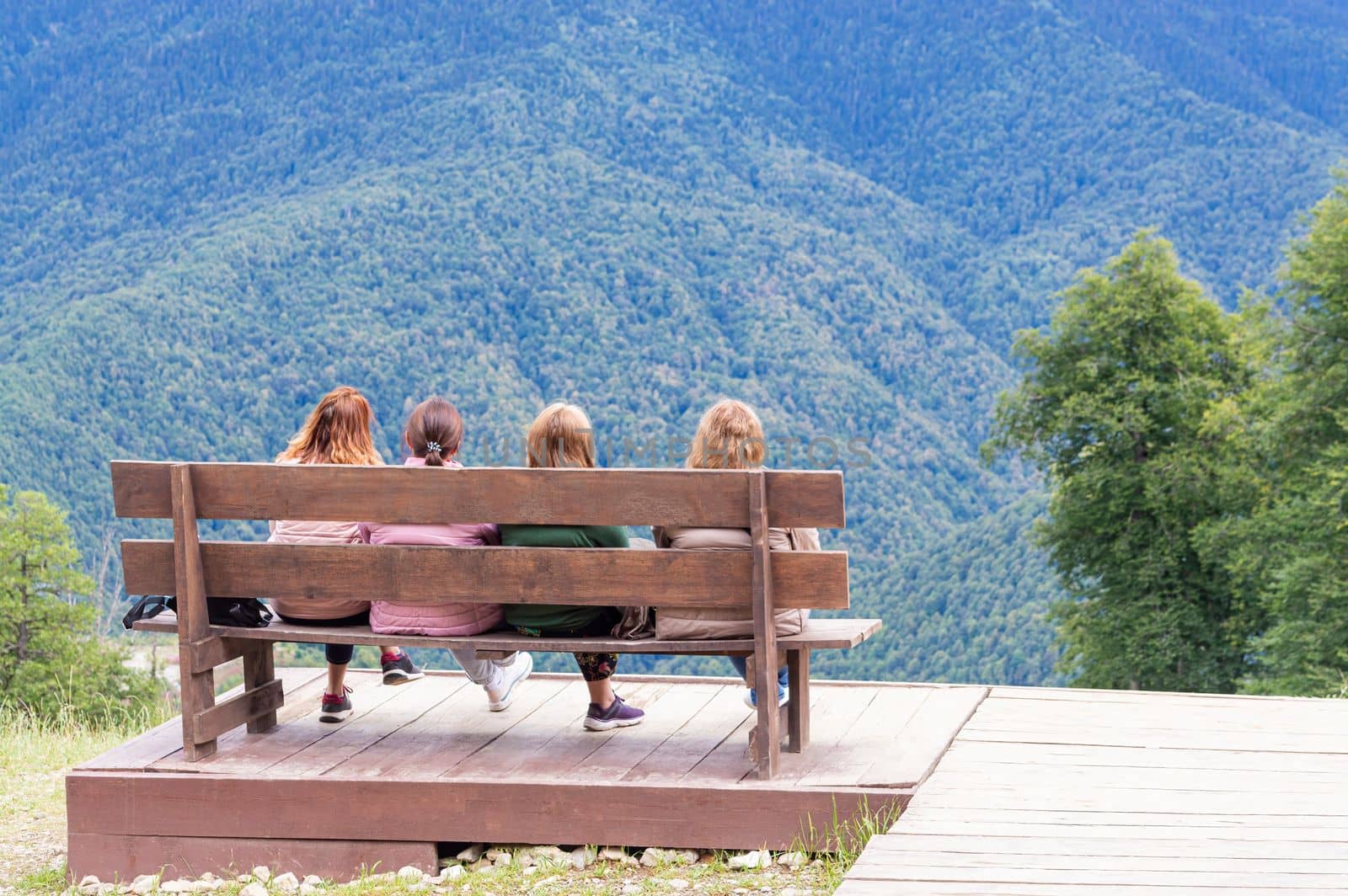 the girls on the bench admire the mountain scenery by roman112007