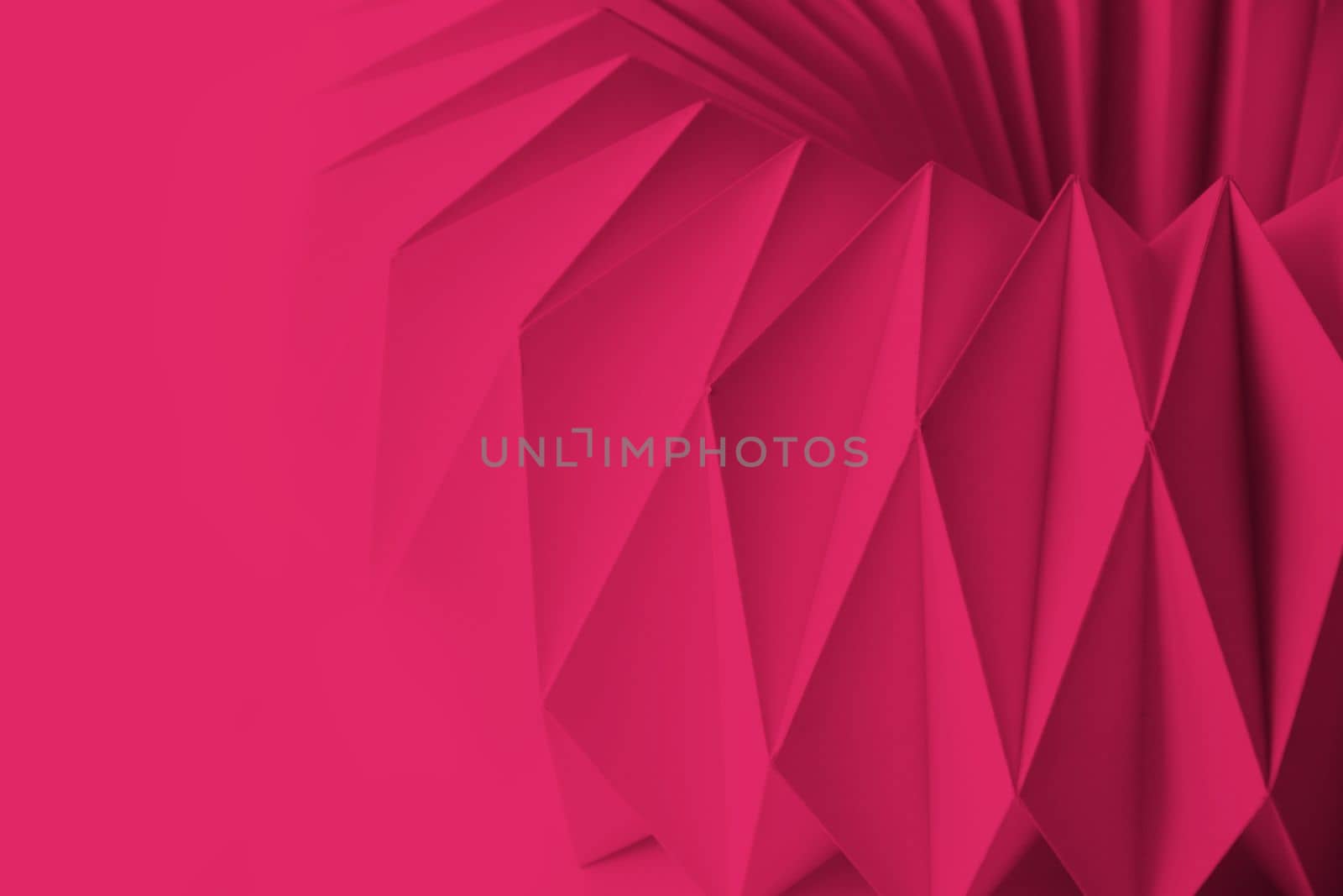 Macro Viva Magenta image of paper folded in geometric shapes, three-dimensional effect, abstract background. Out of focus. Trendy color 2023 Viva Magenta. High quality photo