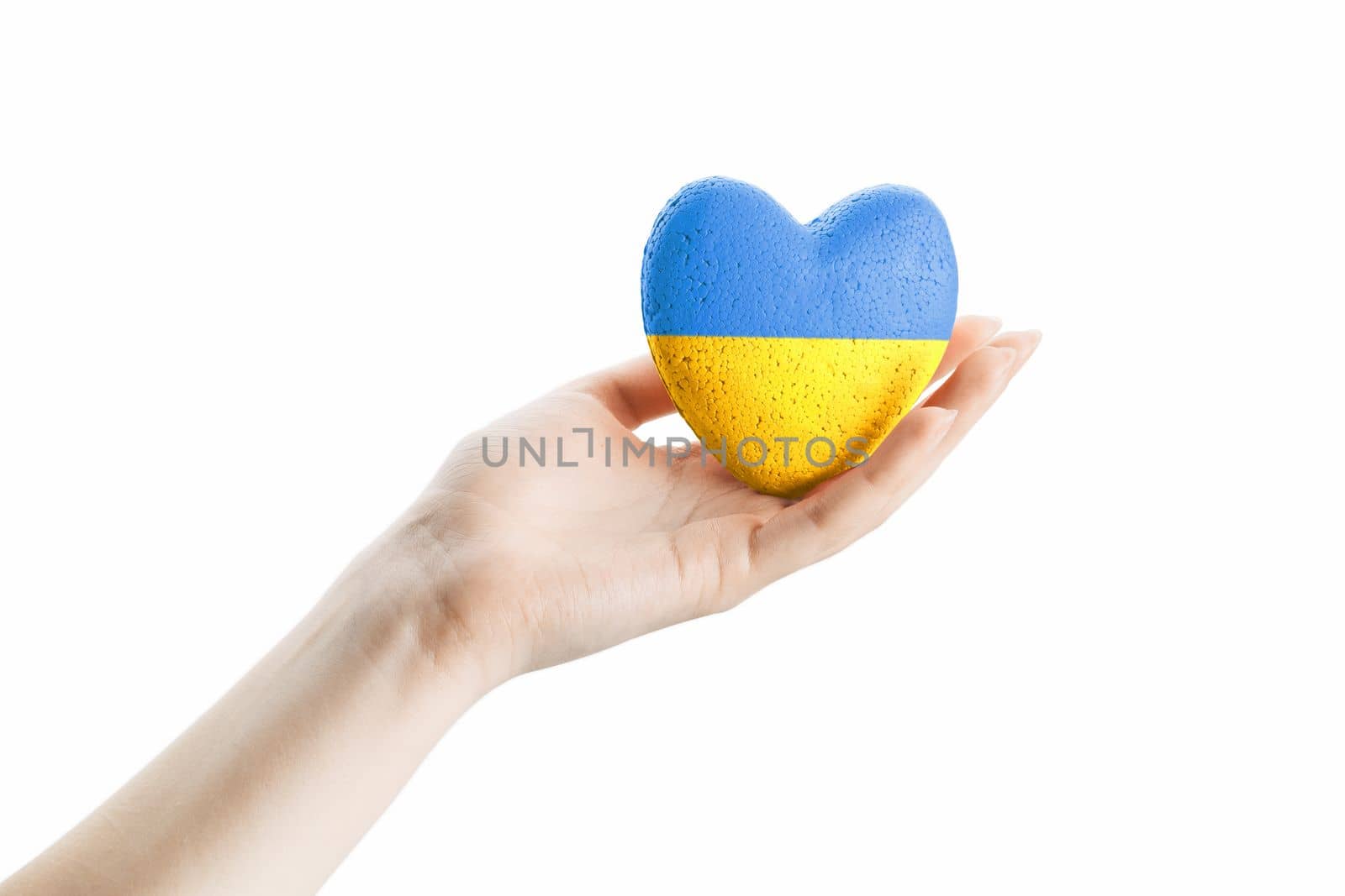 Female hand holds blue yellow ukraine heart on light background. concept needs help and support, truth will win
