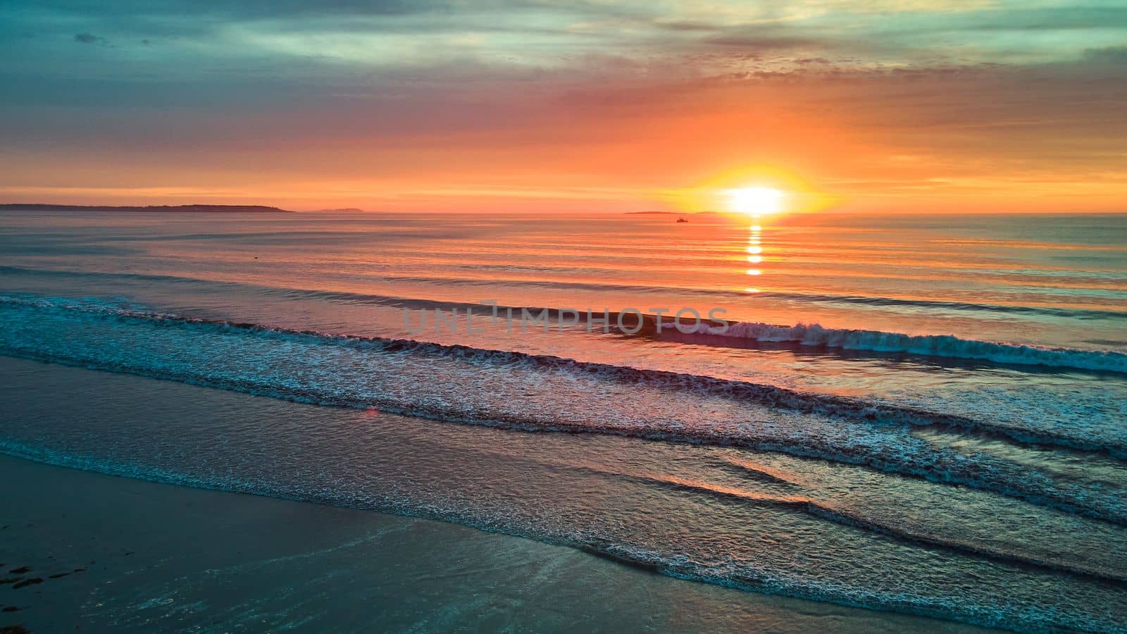 Magical sunrise aerial over beach with ocean waves in Maine by njproductions