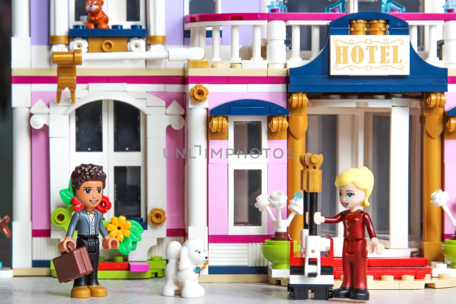 Moscow, Russian Federation - March 14, 2022. Lego mini figures are manufactured by Lego Group. The visitor arrived at the hotel. The guest is met by a porter on the street. Studio shot.