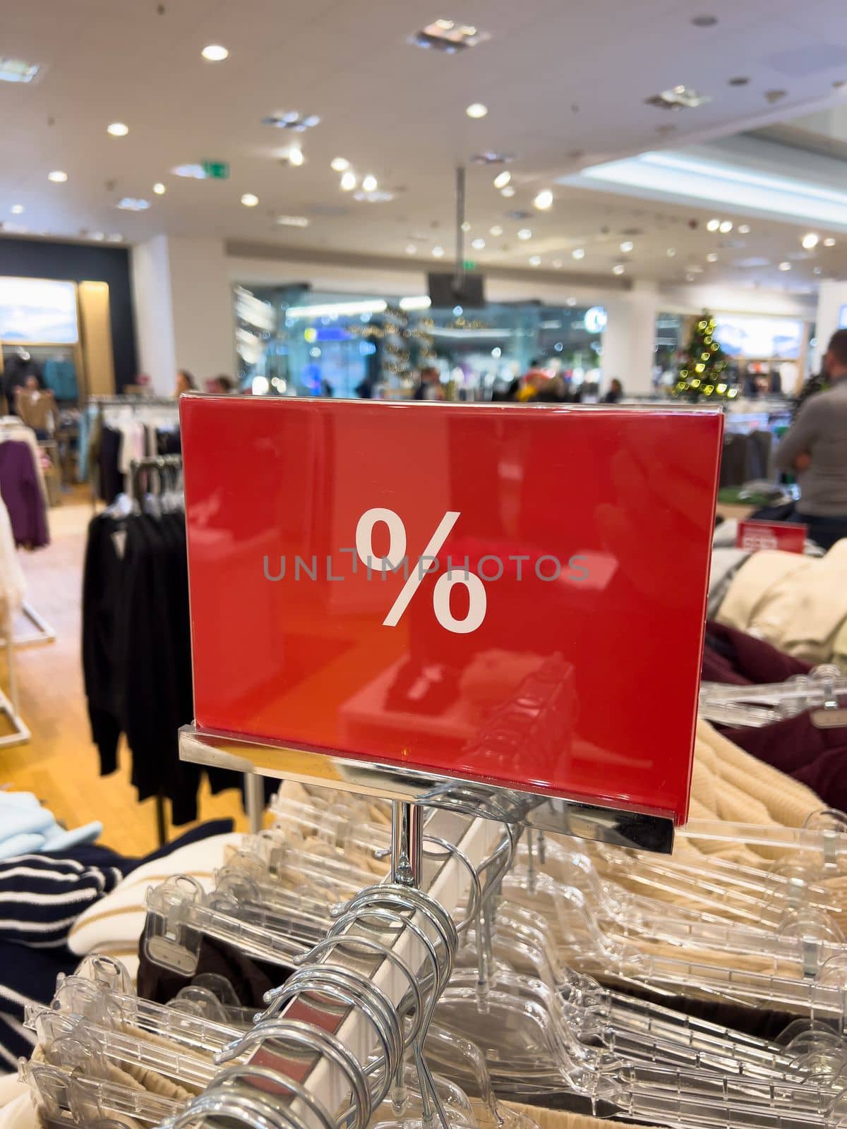 red and white percent sale sign in store mobile photo by Chechotkin