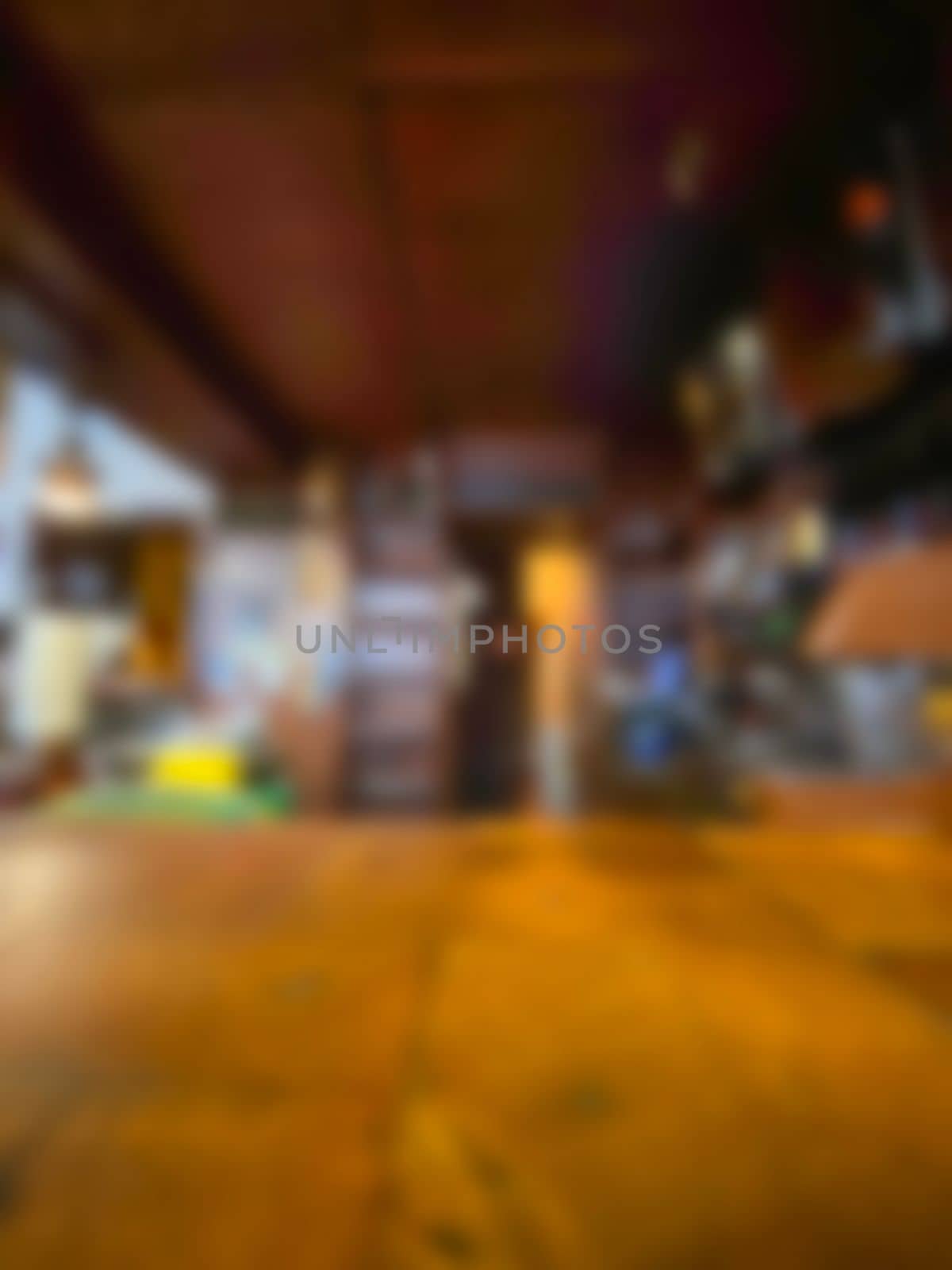 defocused on purpose. Wood table Bar counter in dark night cafe,restaurant background .Lifestyle and celebration concepts ideas