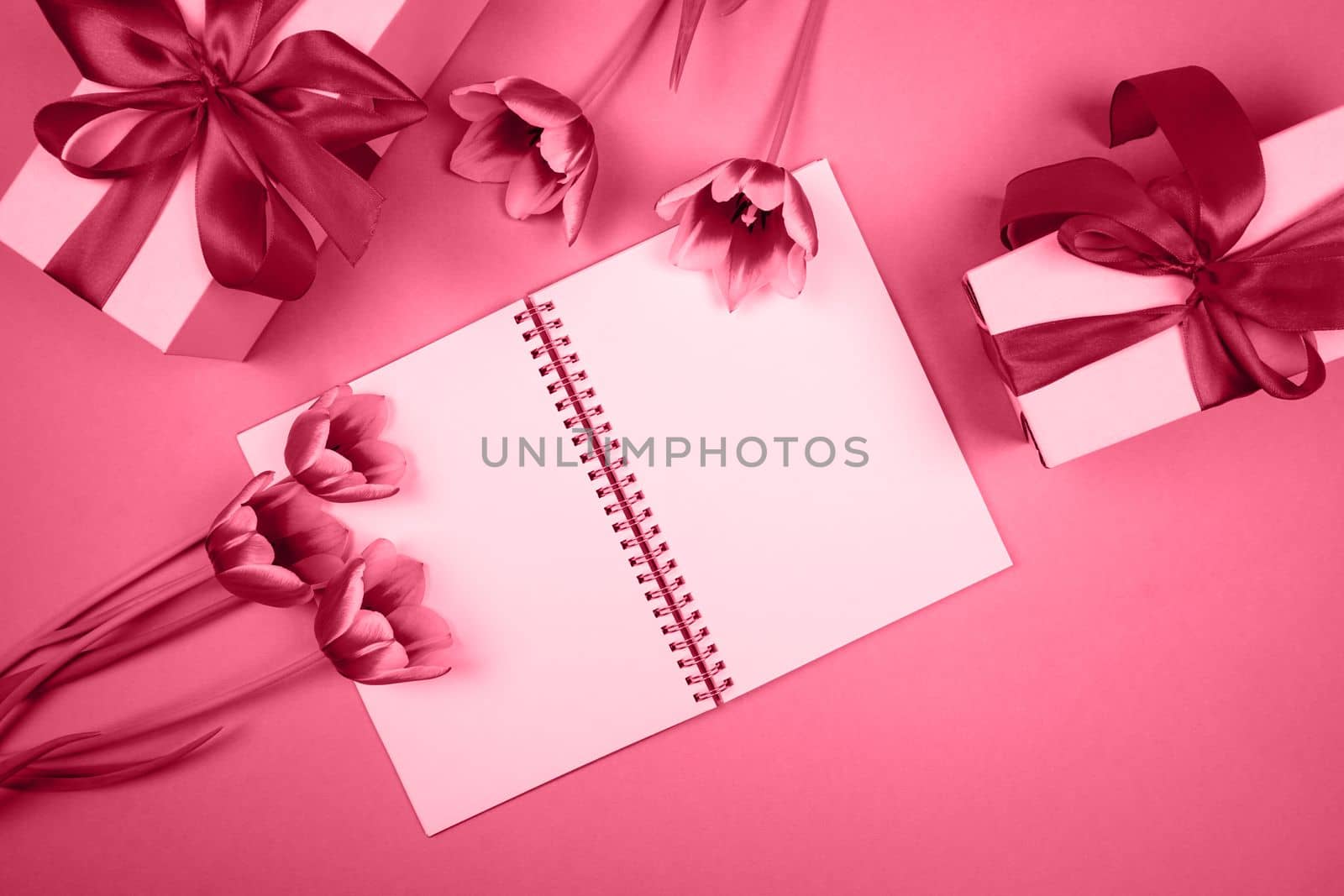 There is a notebook, gifts and flowers on the table. The color of the year 2023.