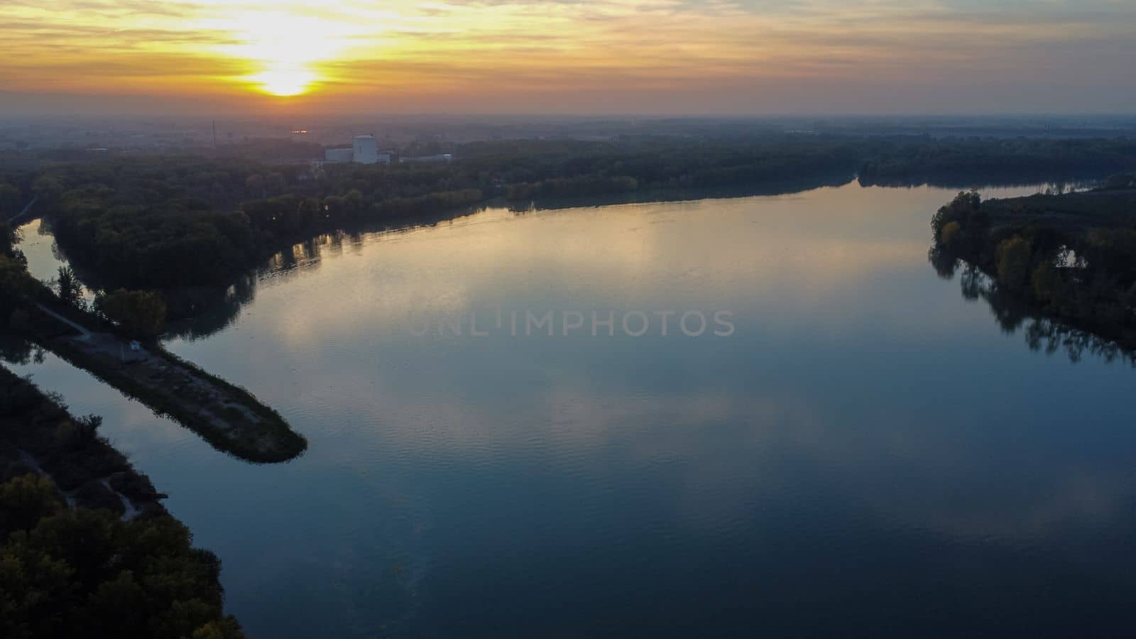 sunset over a bridge in the river in autumn