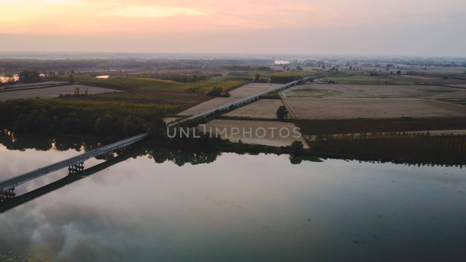 sunset over a bridge in the river in autumn