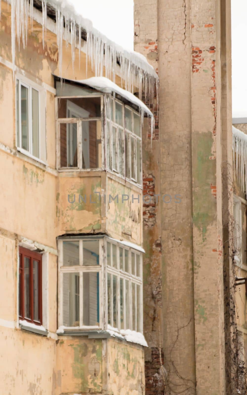 Icy, small icicles hang on the edge of the roof, spring or winter. by anarni33