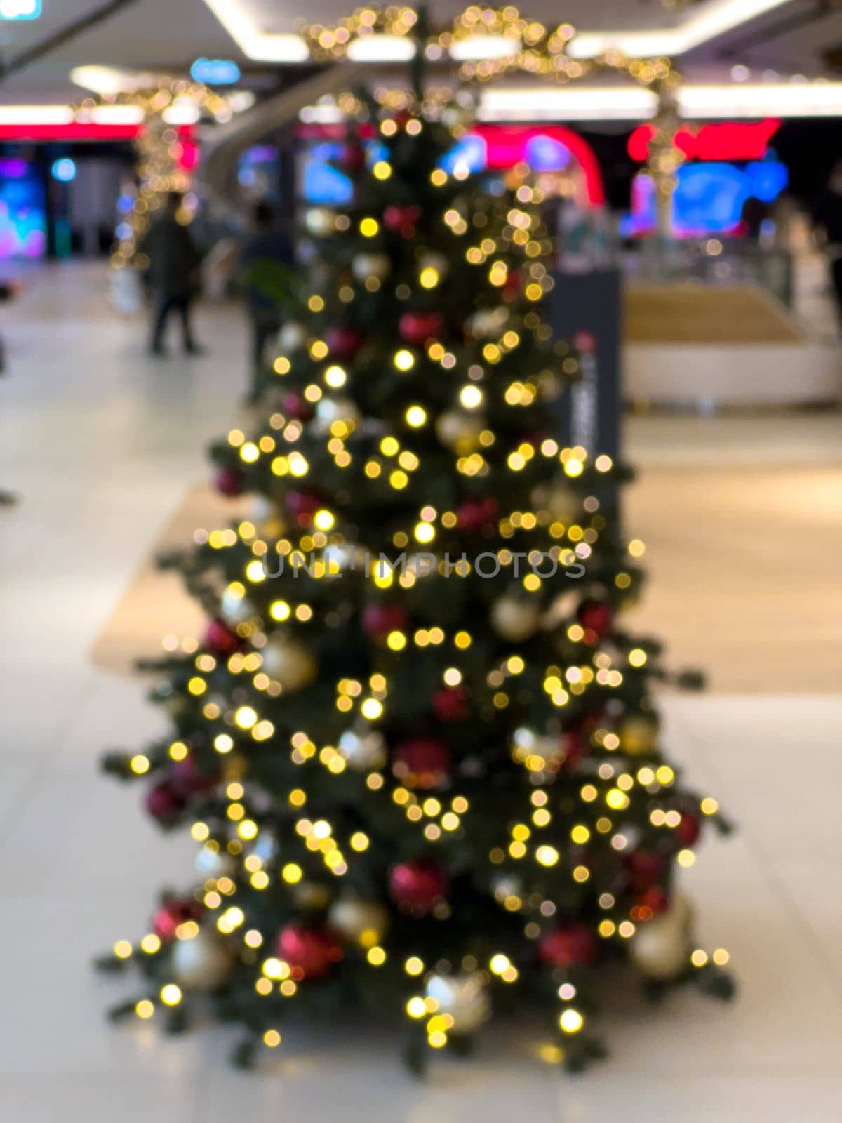 blurred decorated christmas tree in shopping mall background by Chechotkin