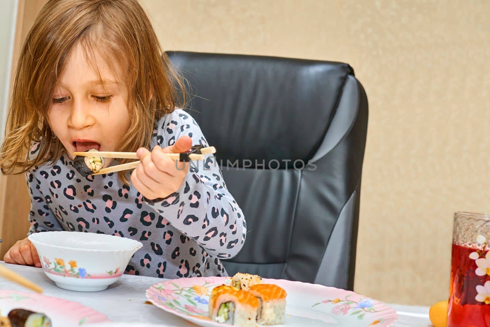 Wonderful child is happy to eat sushi with soy sauce by jovani68