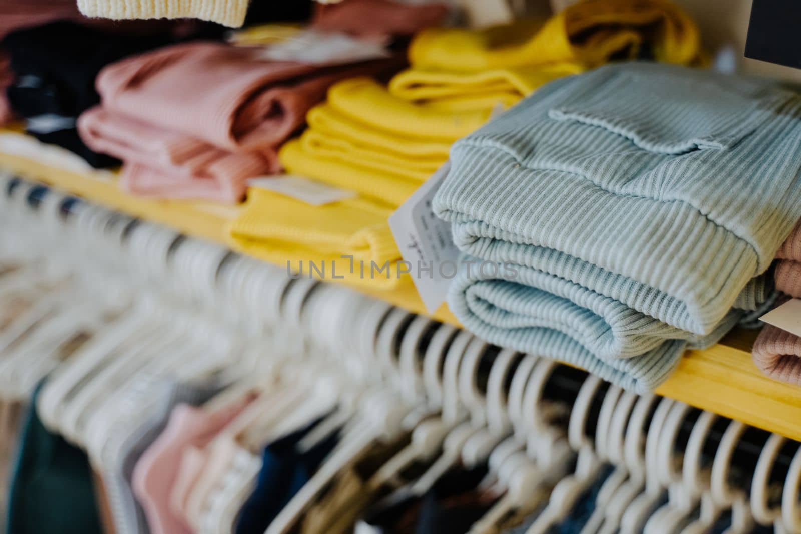 Sale of clothes. Children's clothing and footwear store. Pants in blue, pink and yellow. by Rodnova