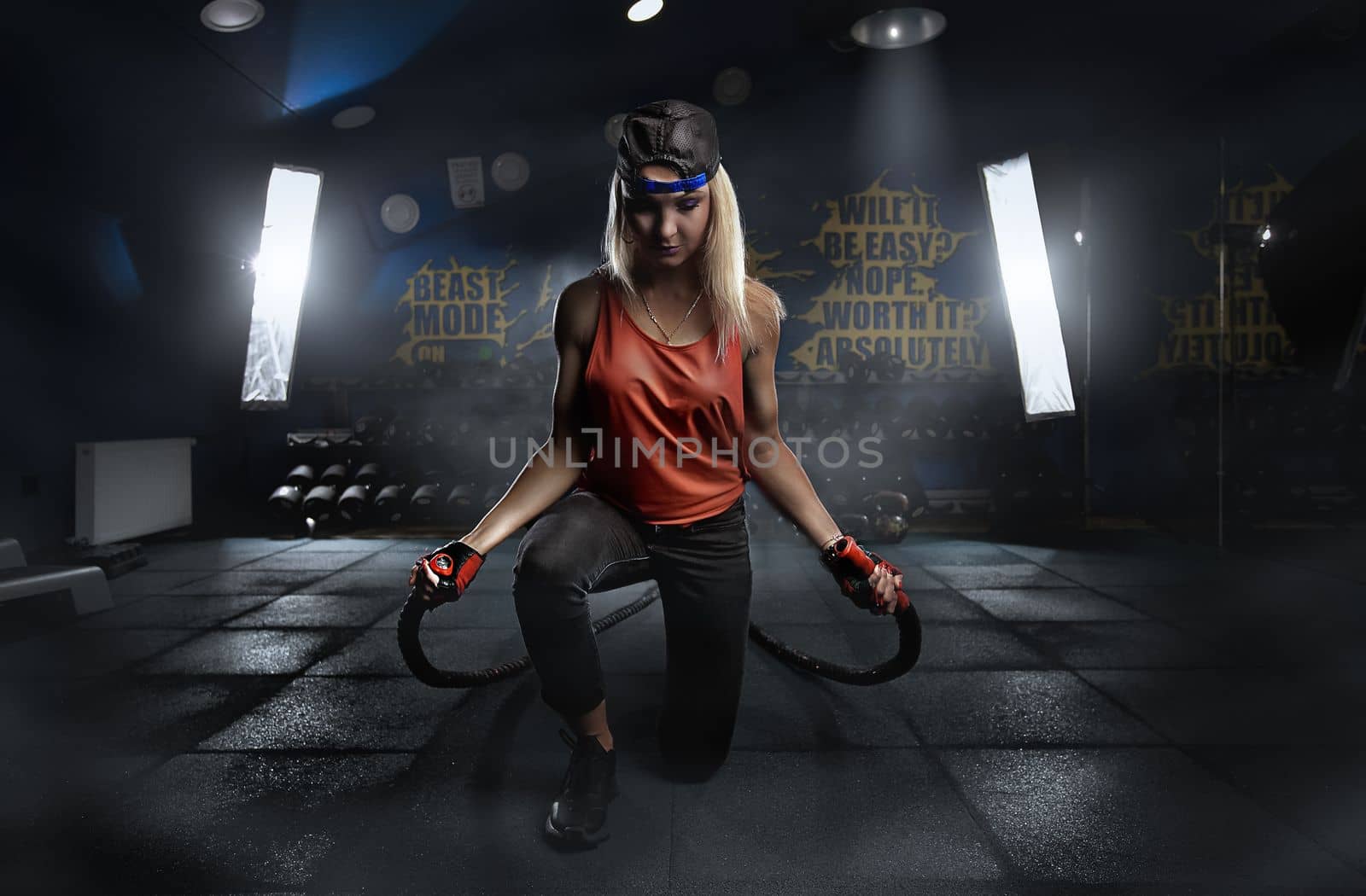 Beautiful fitness woman lifting dumbbells . Fitness sporty woman showing her well trained body . A beautiful girl's body with rippling muscles from strength training