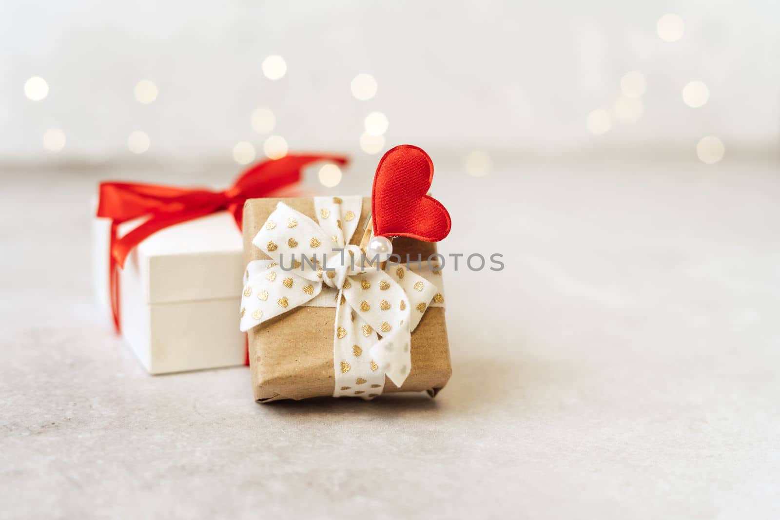 Gift or present box with red bow and heart shape on lights background. Copy space for text and design. Valentine day gift. Banner for Christmas, hew year, birthday concept.