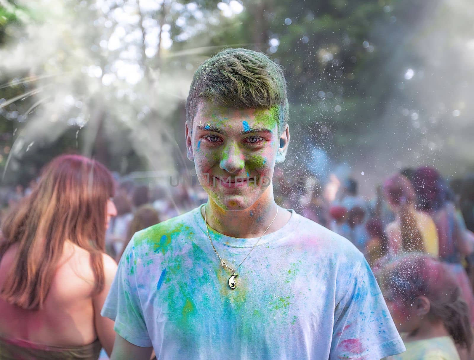 Young people, teenagers and adults celebrate the Holi event in Ukraine in Chernivtsi on March 8 in 2022. They have fun and throw paint at each other. High quality photo