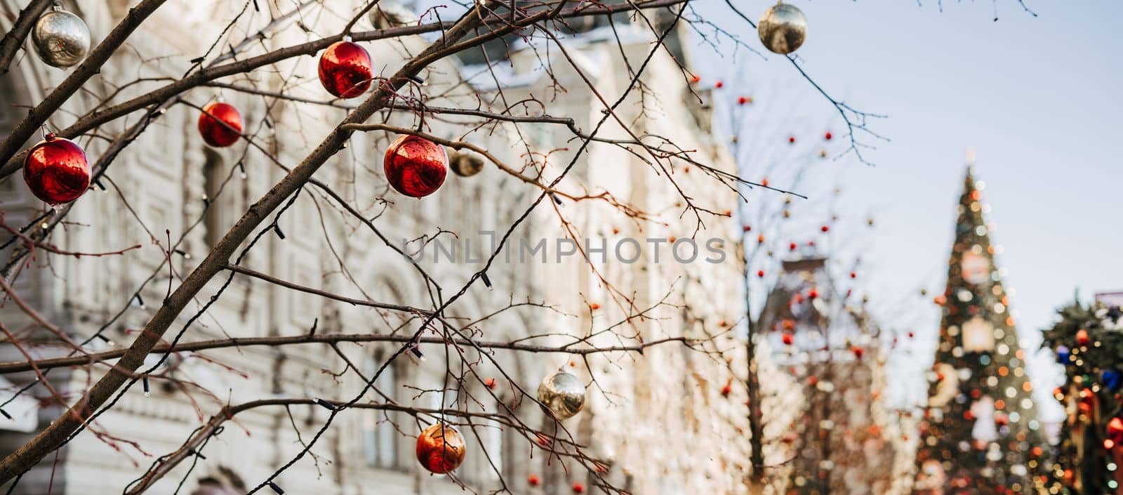 Close up of balls on christmas fir tree. Bokeh light garlands in background with copy space. Merry christmas and happy new year