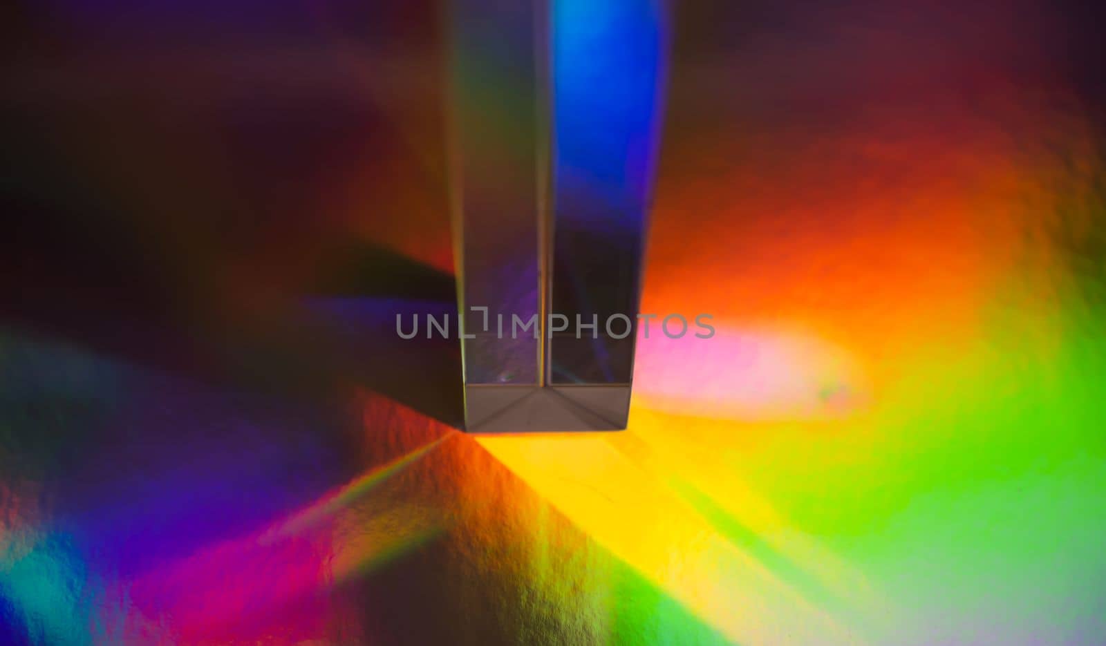 Glass prism on bright rainbow colors abstract background. Colorful polygonal multicolor banner. by PaulCarr