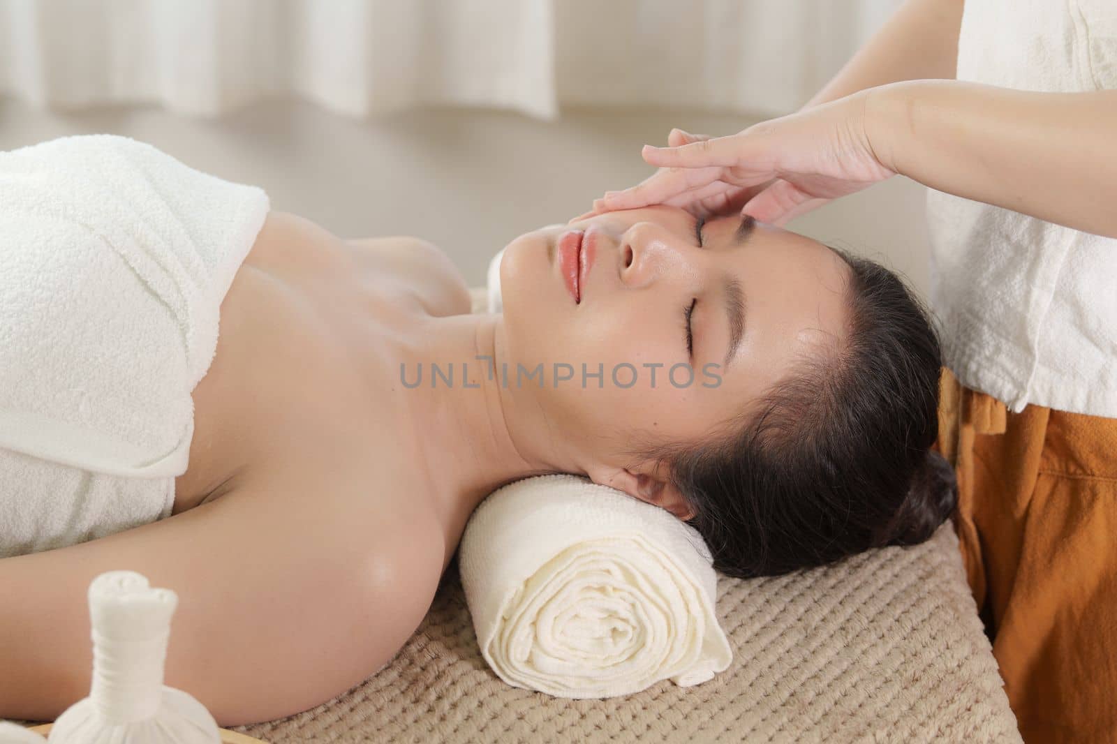 Young woman doing relaxing massage in spa salon. Female being massaged by a masseur. Spa and medicine concept.