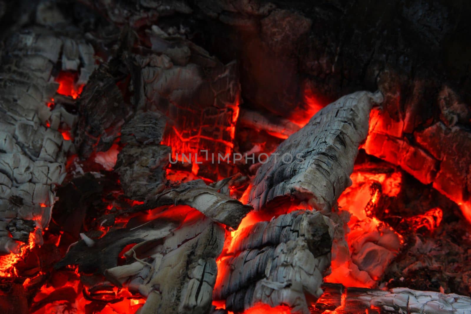 Smoldered logs burned in vivid fire close up. Atmospheric background with flame. Background from a fire by IrinaKur