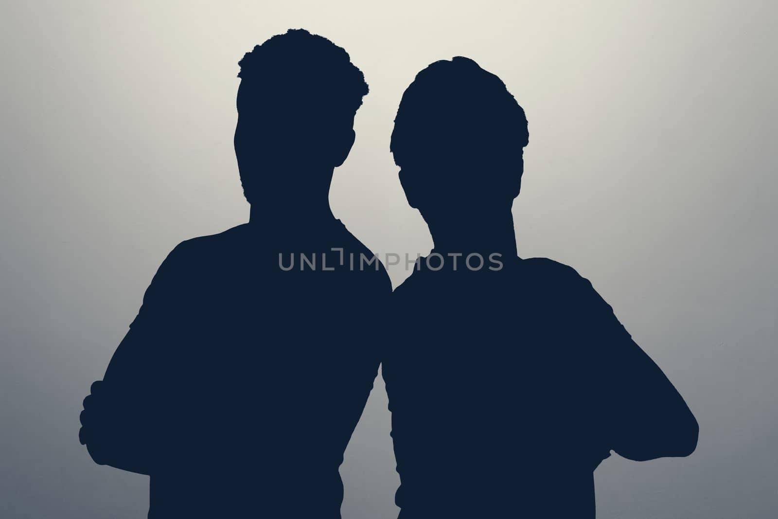 Two male silhouettes in studio. Two men standing together staying anonym hiding their identity. High quality photo