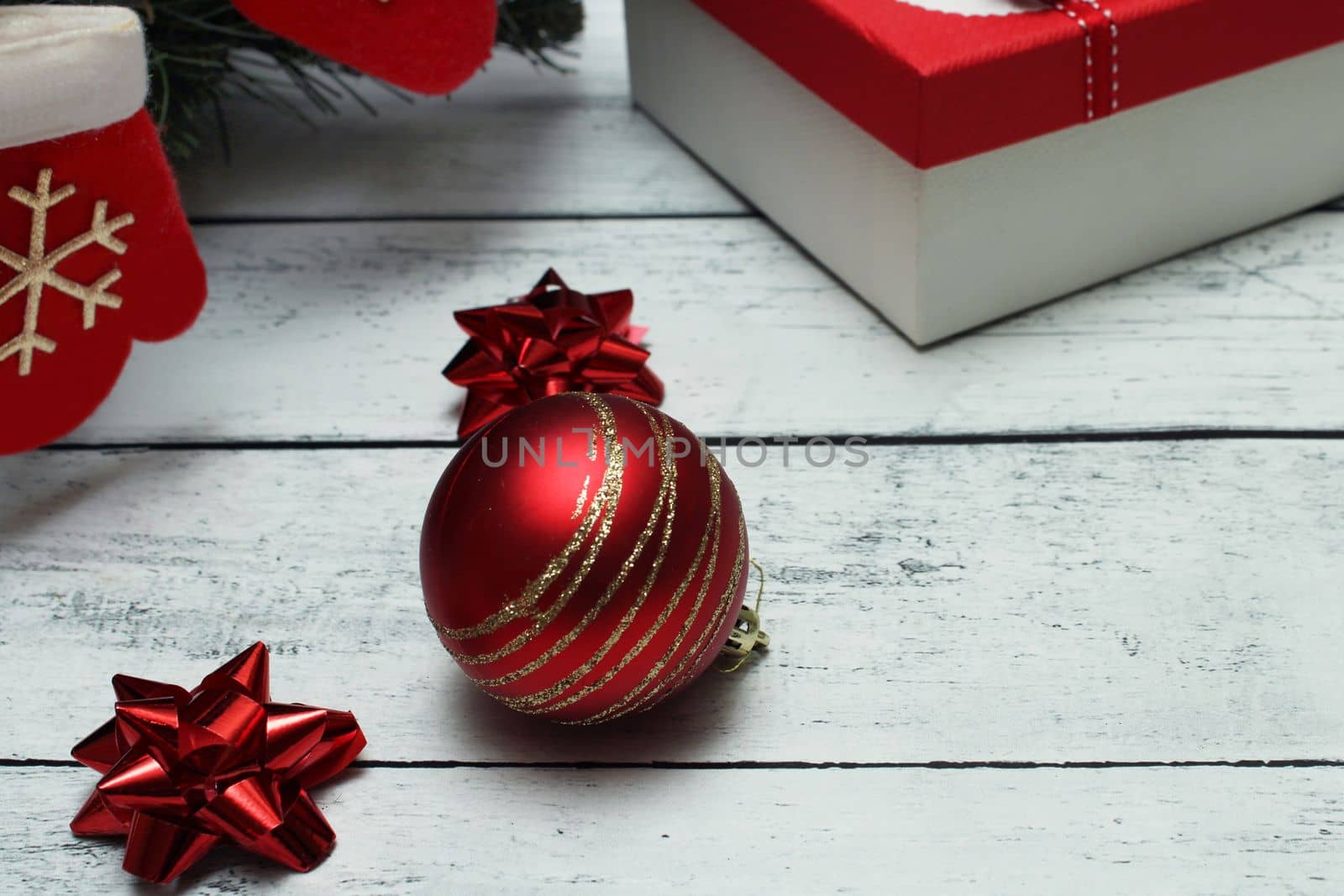 Christmas red and silver background with balls, bows, Christmas sock and gifts on a wooden table with copy space