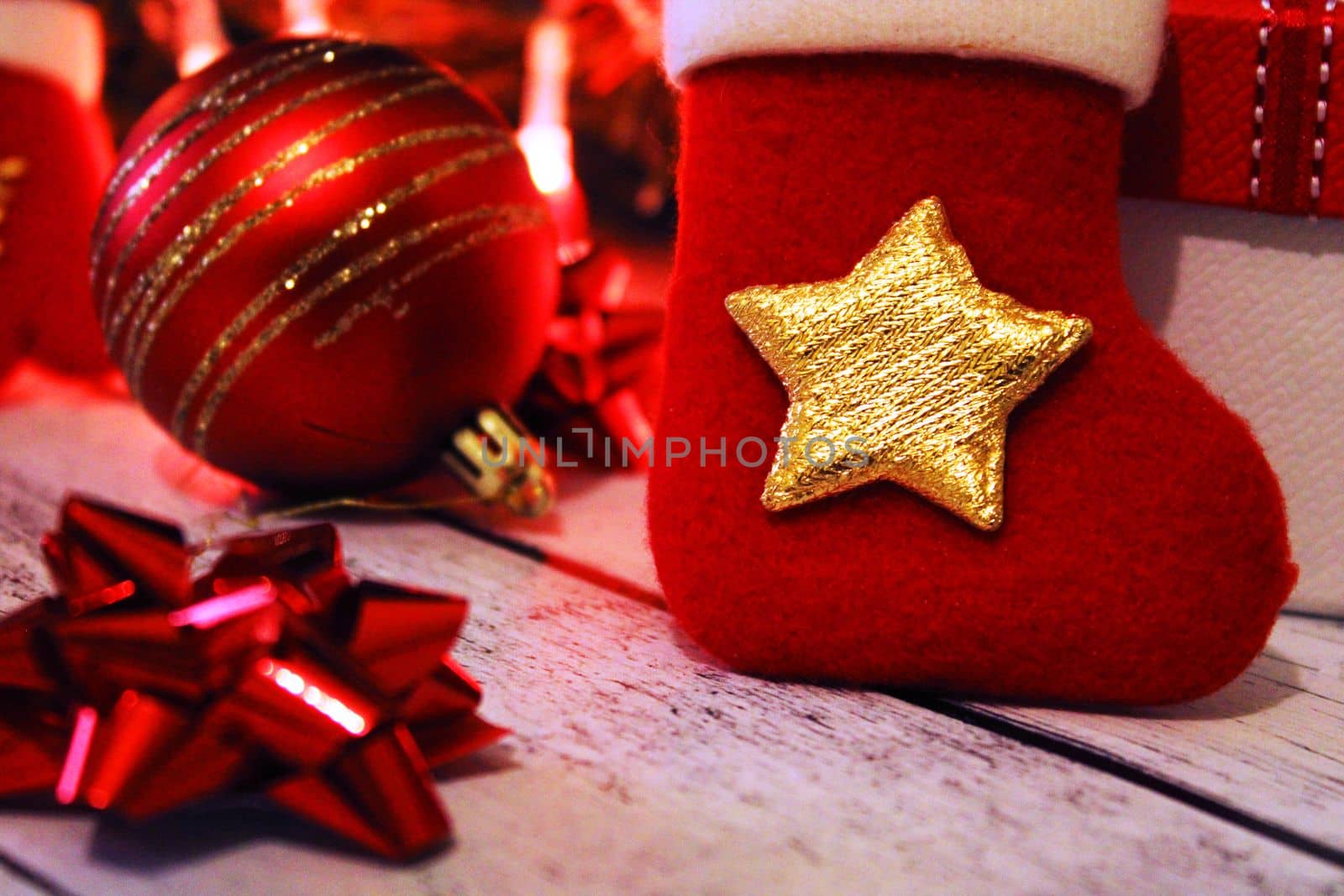 Christmas red and gold background with balls, bows, Christmas sock and gifts.
