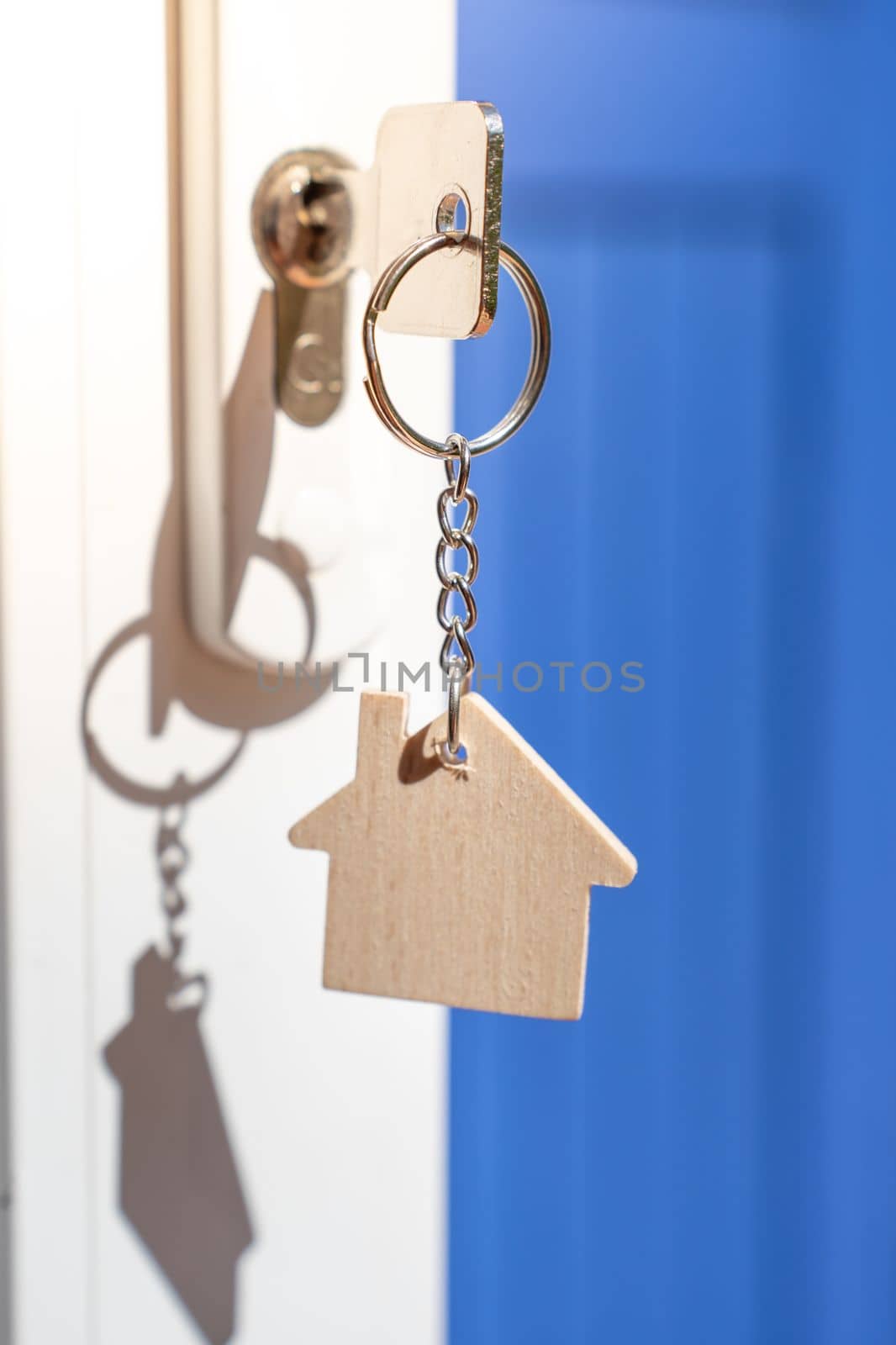 Opening door to a new home with key and home shaped keychain. Property and new home concept by PaulCarr