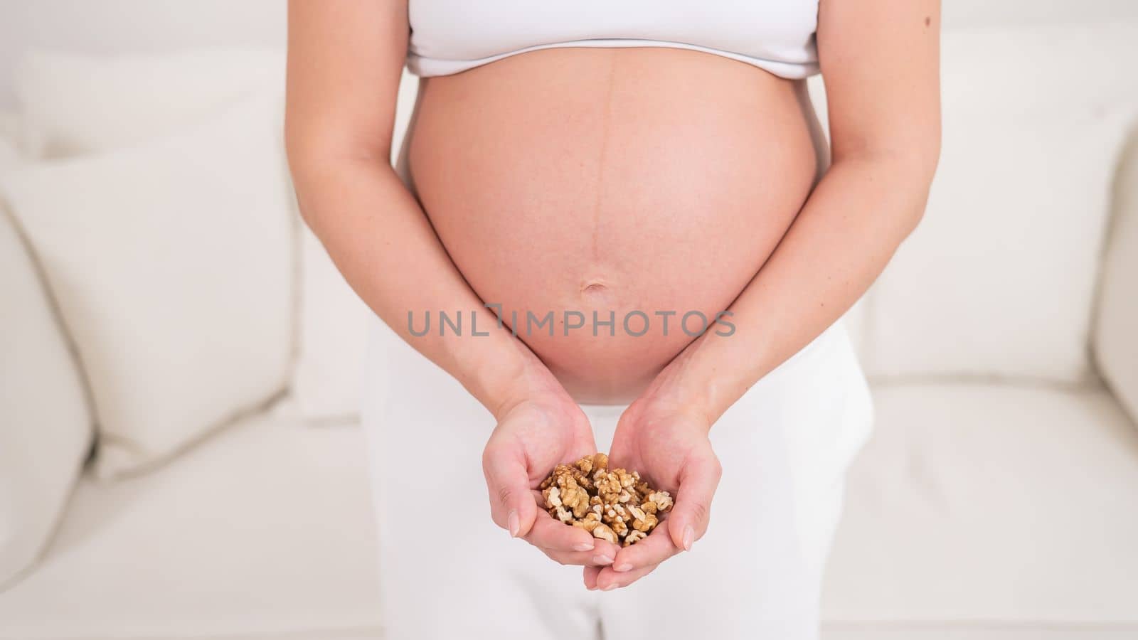 Pregnant woman holding a handful of walnuts