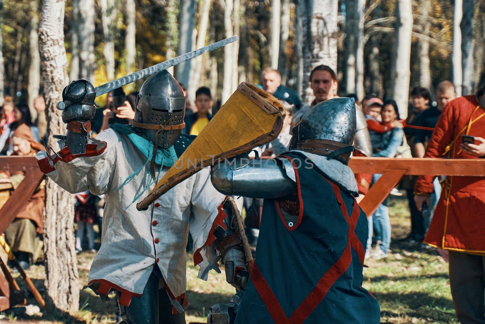 Reconstruction of medieval jousting tournaments. Knights in armor and helmets, fighting with swords and shields in the arena. Festival of historical clubs. Bishkek, Kyrgyzstan - October 13, 2019