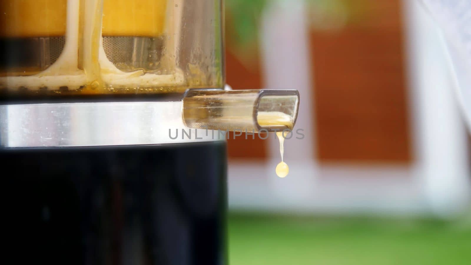 close-up, drops of freshly squeezed orange juice drip from the juicer by djtreneryay