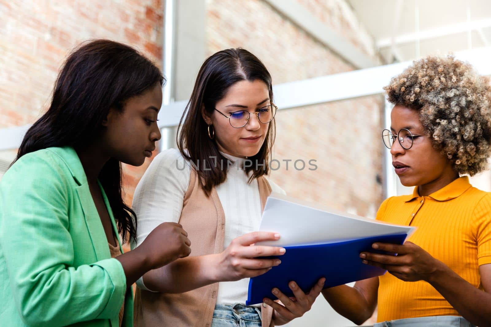 Group of multiracial women look over some work documents in the office. Start up concept. Women at work concept.