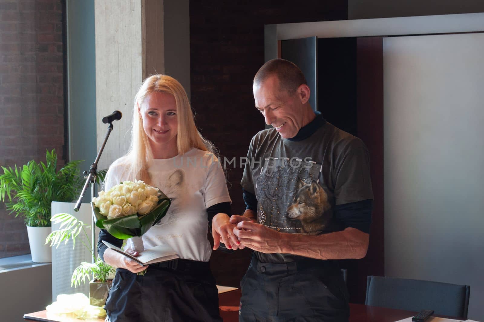 couple of motorbikers marry wedding in municipality, groom wears a ring to the bride, High quality photo