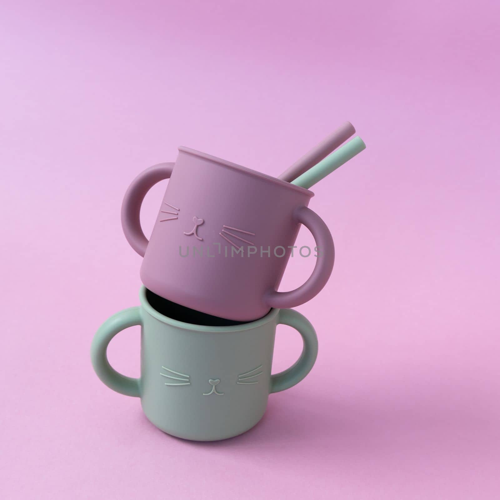 Modern pastel color silicone sippy cups with straws on pink background. Baby tableware, first feeding, serving concept. For instagram use. by Ri6ka