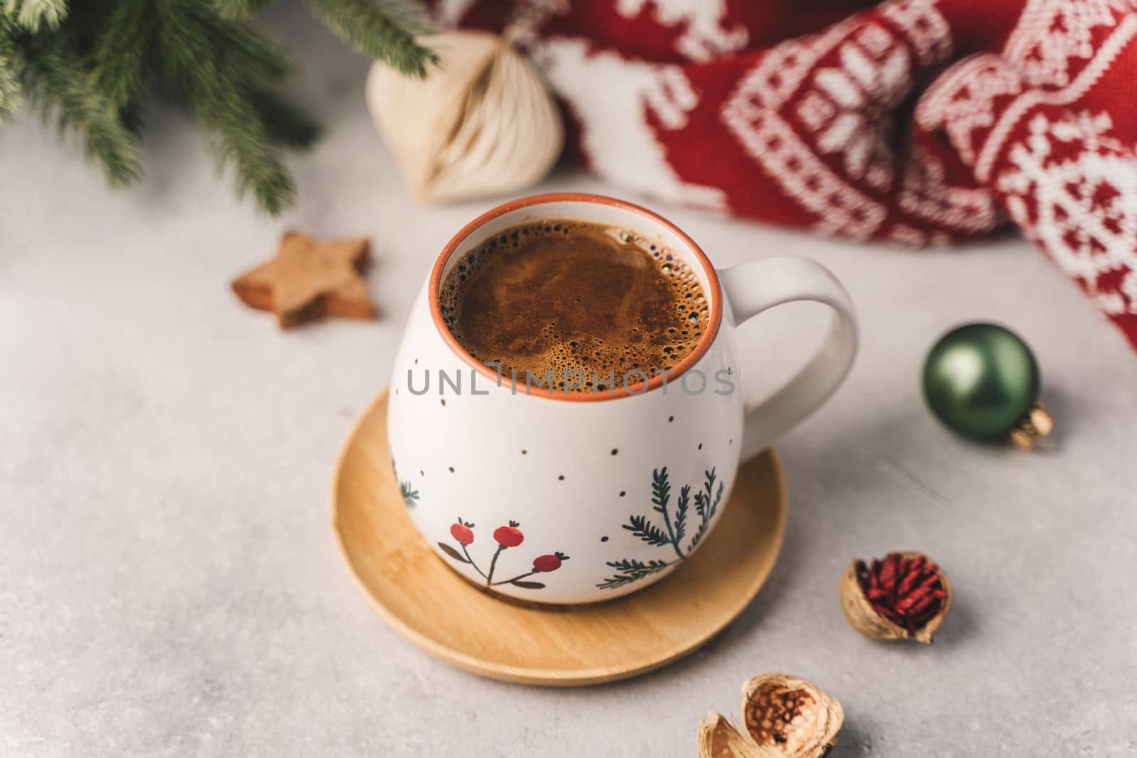 Cup of hot coffee with fir tree, wooden star and warm cozy sweater. Christmas greeting card, lights background. Xmas holiday eco nature decorations. Zero waste concept.