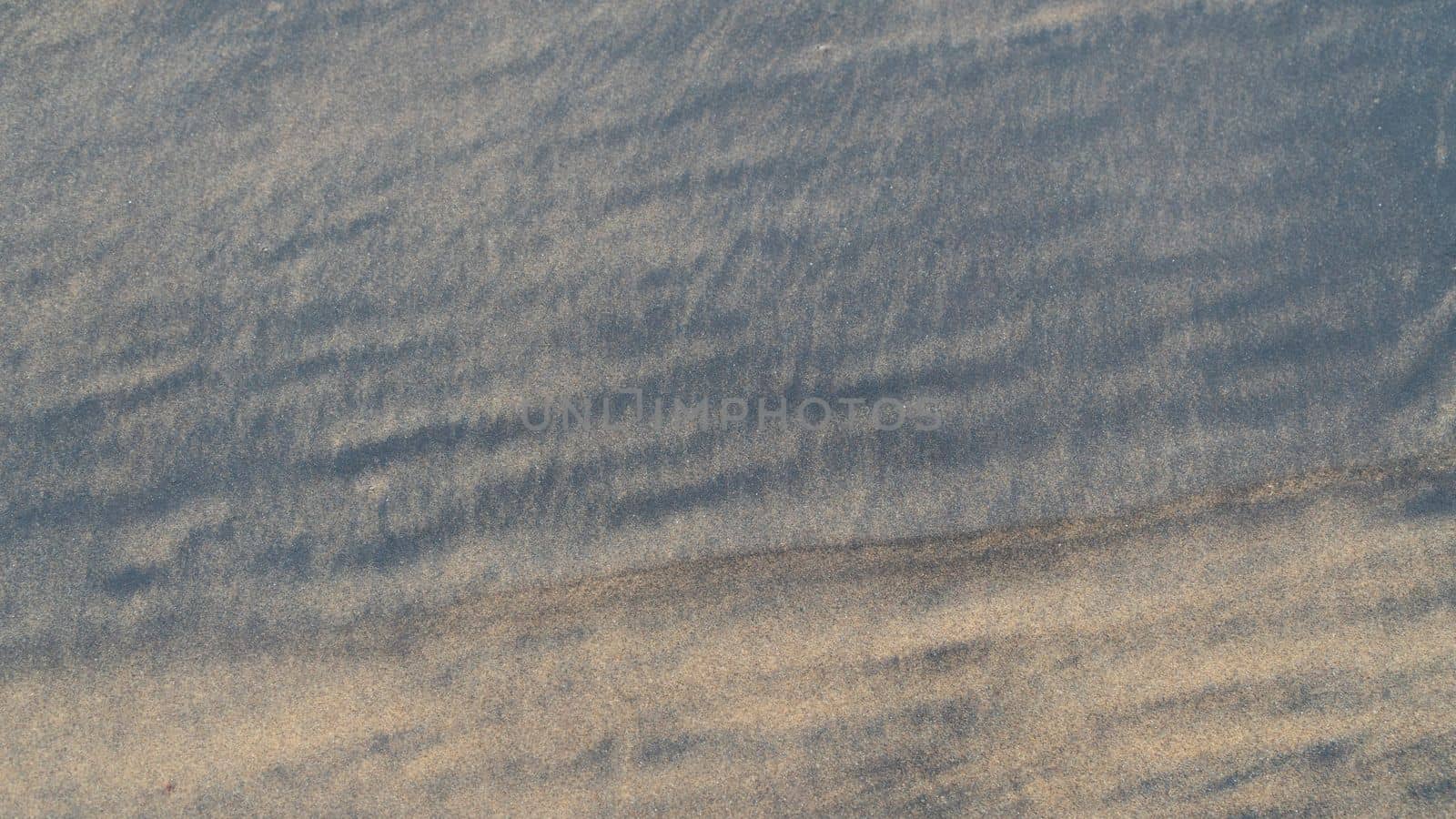 Black and brown sea sand close-up background. High quality photo