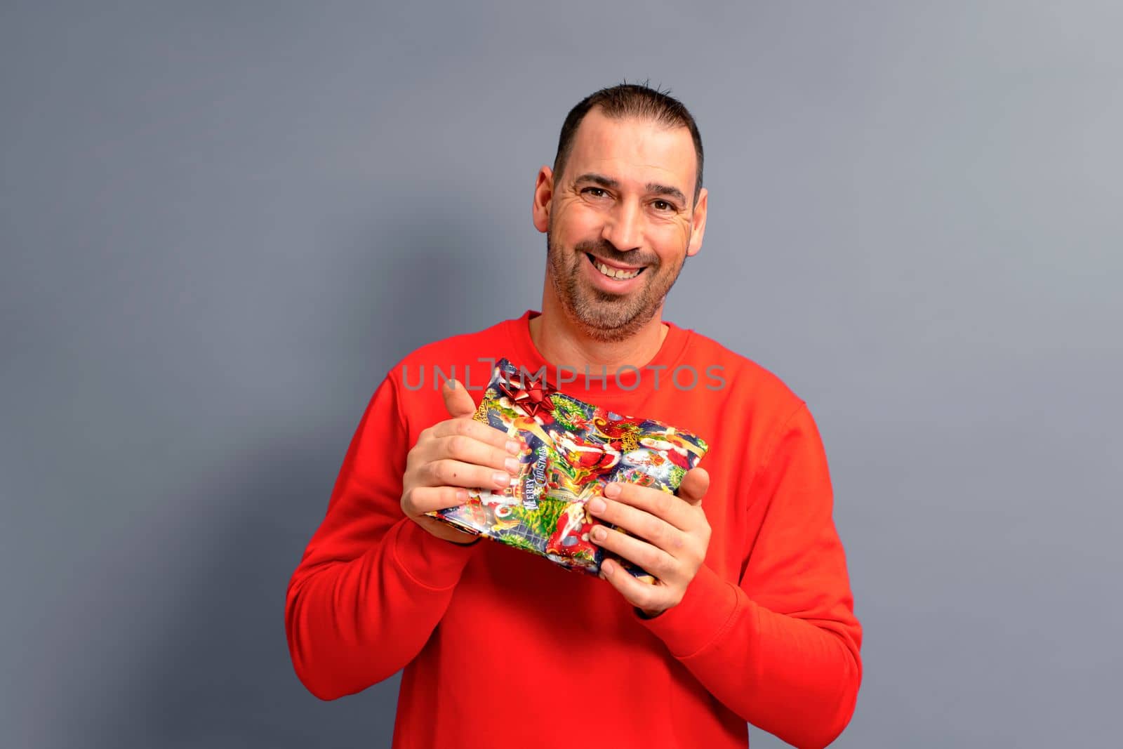 It's for you my love. Portrait of romantic romantic lover holding gift box for women's day giving girlfriend elegant clothes isolated over gray color background.