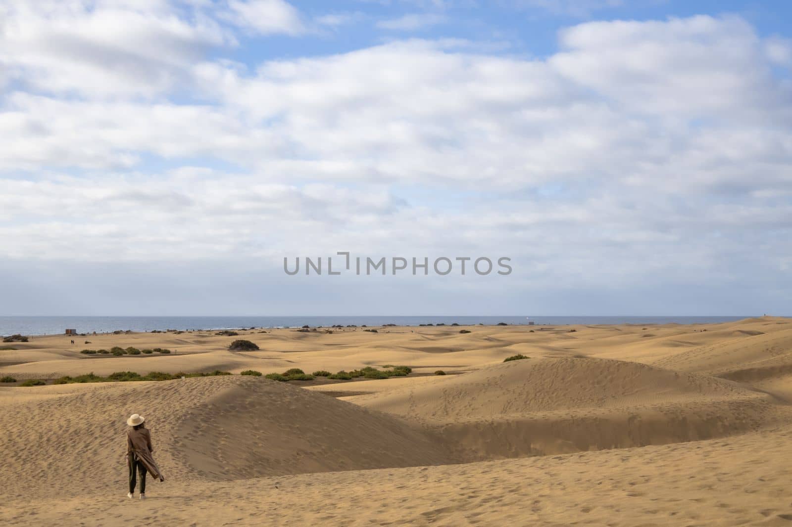 Evening Desert walk on sand dunes in Gran Canaria. Woman walking in the desert