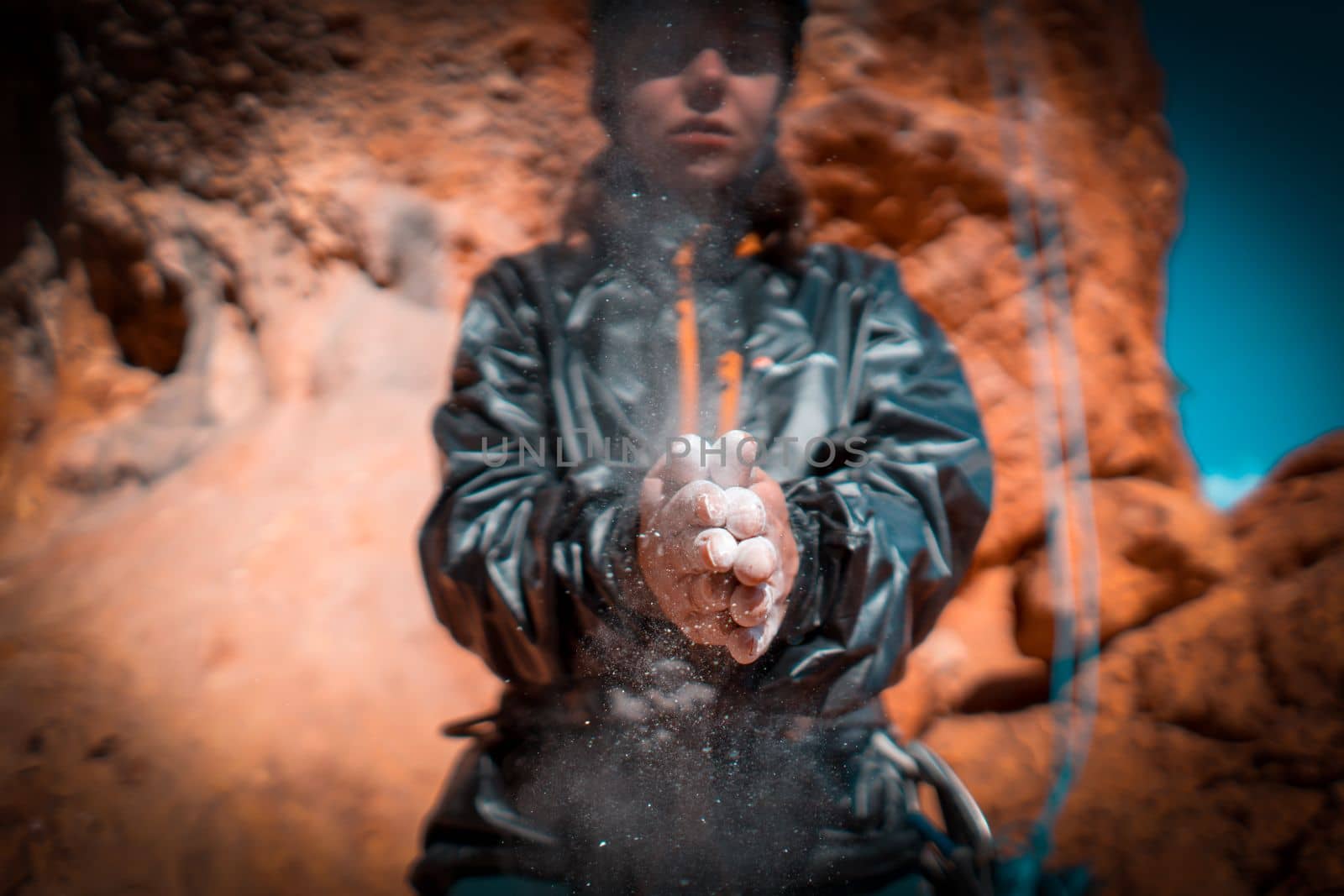 The girl is engaged in rock climbing, uses white powder of magnesia, claps her hands close-up, the woman leads an active lifestyle, climbs the mountains outdoor.