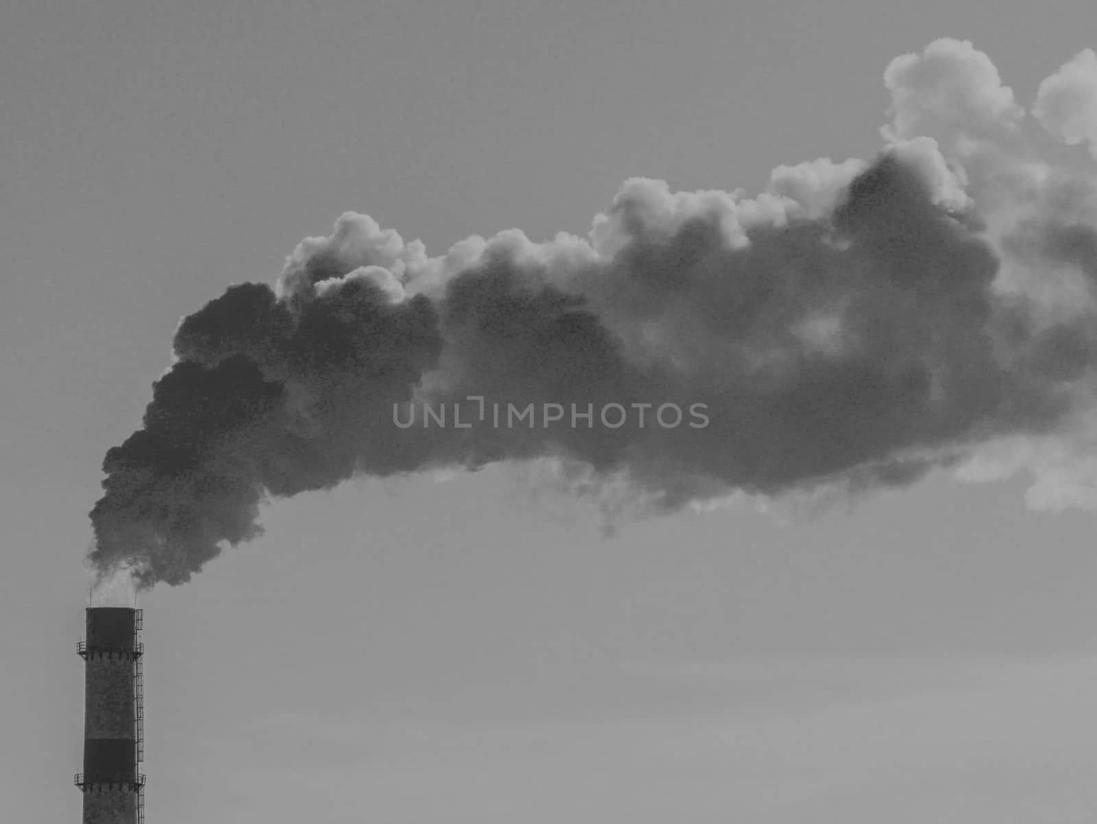 Black and white image of a smoking chimney against the sky. by gelog67