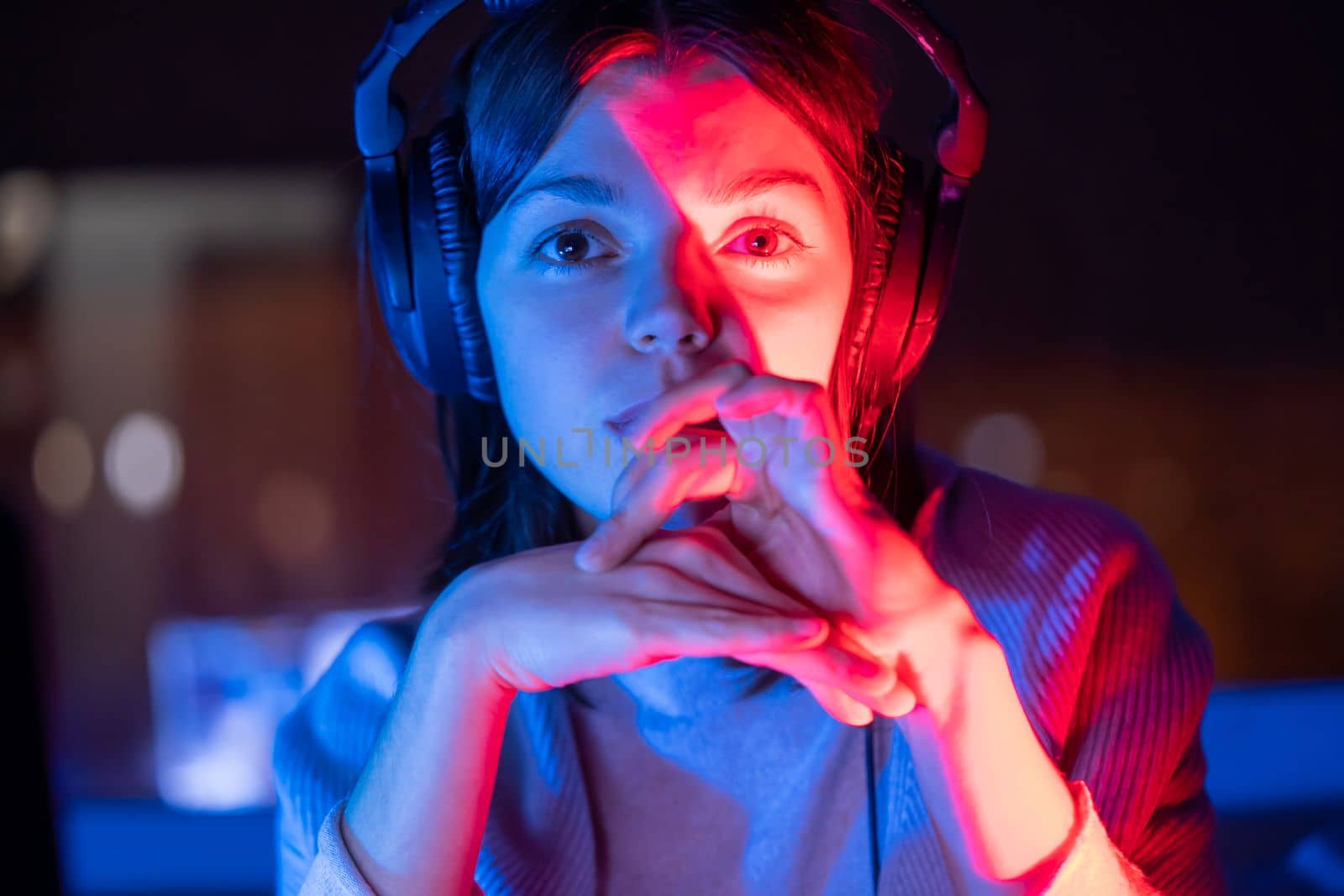 A young girl holds headphones and is listening and composing music, a woman sits with a laptop by the window in her room, works and enjoys the sound.