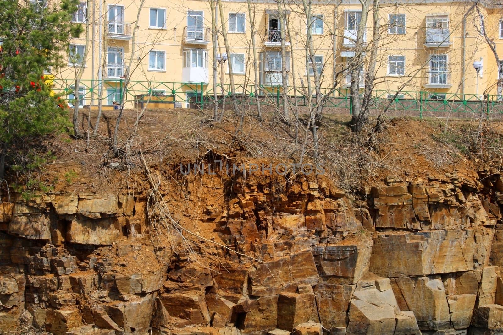 A multi-storey building standing on a cliff of a rocky shore.