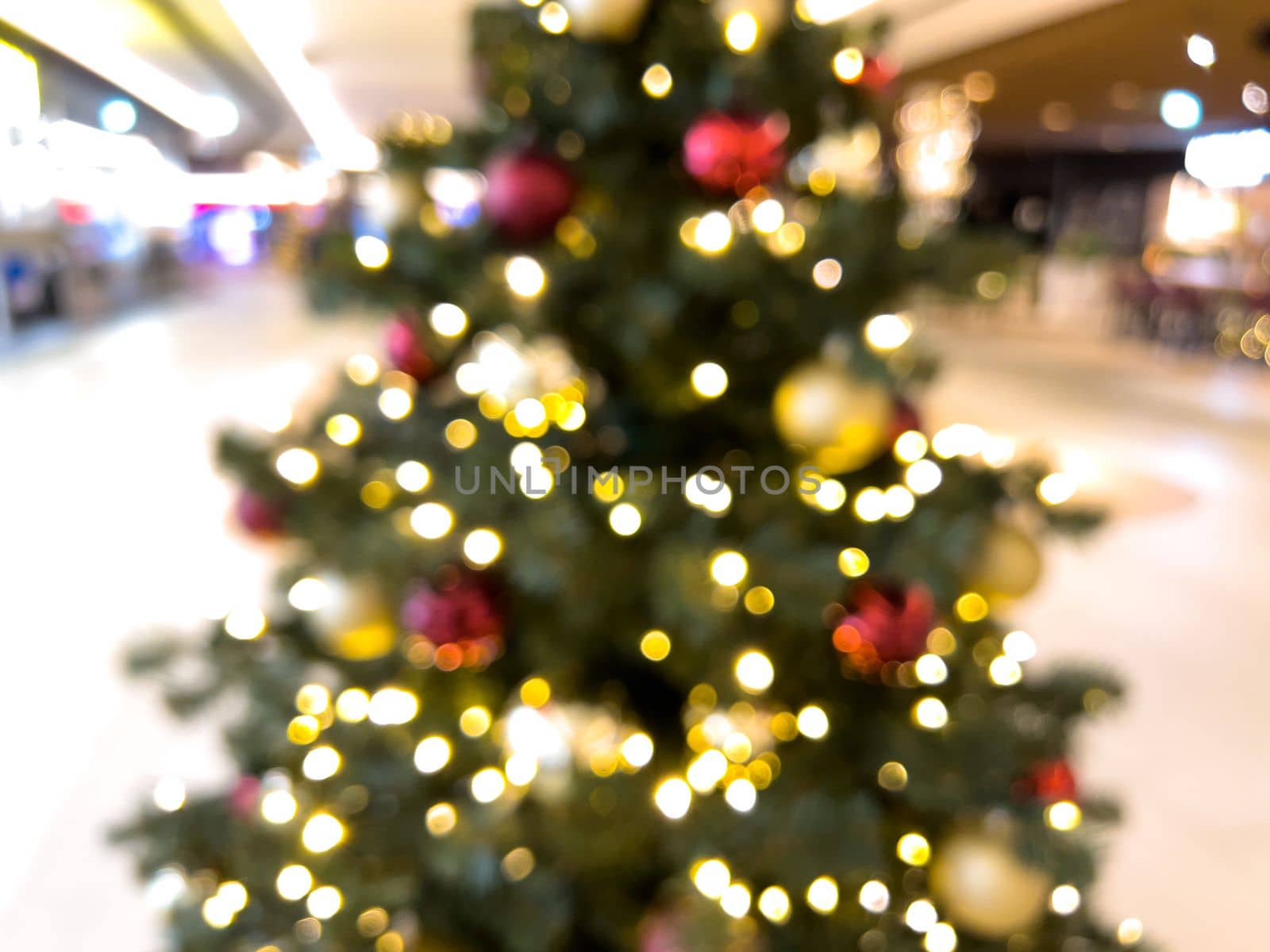 blurred decorated christmas tree in shopping mall background. High quality photo