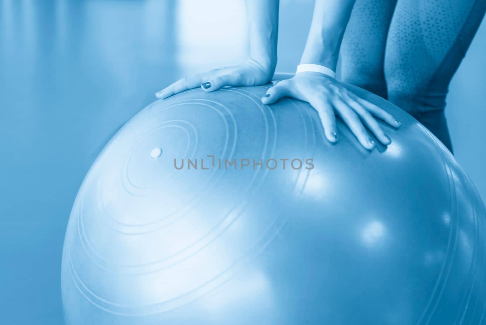 Woman at the gym holding pilates ball, close up view by Mariakray