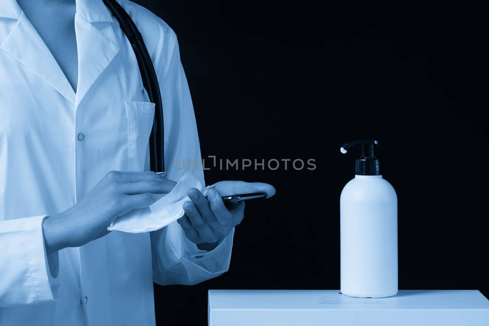 disinfection of the phone with a sanitizer. the doctor disinfects and wipes the smartphone with napkin. copy space